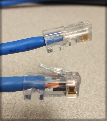The cable on top has a broken tab and should not be used, while the cable on bottom has a tab and is ready to connect.